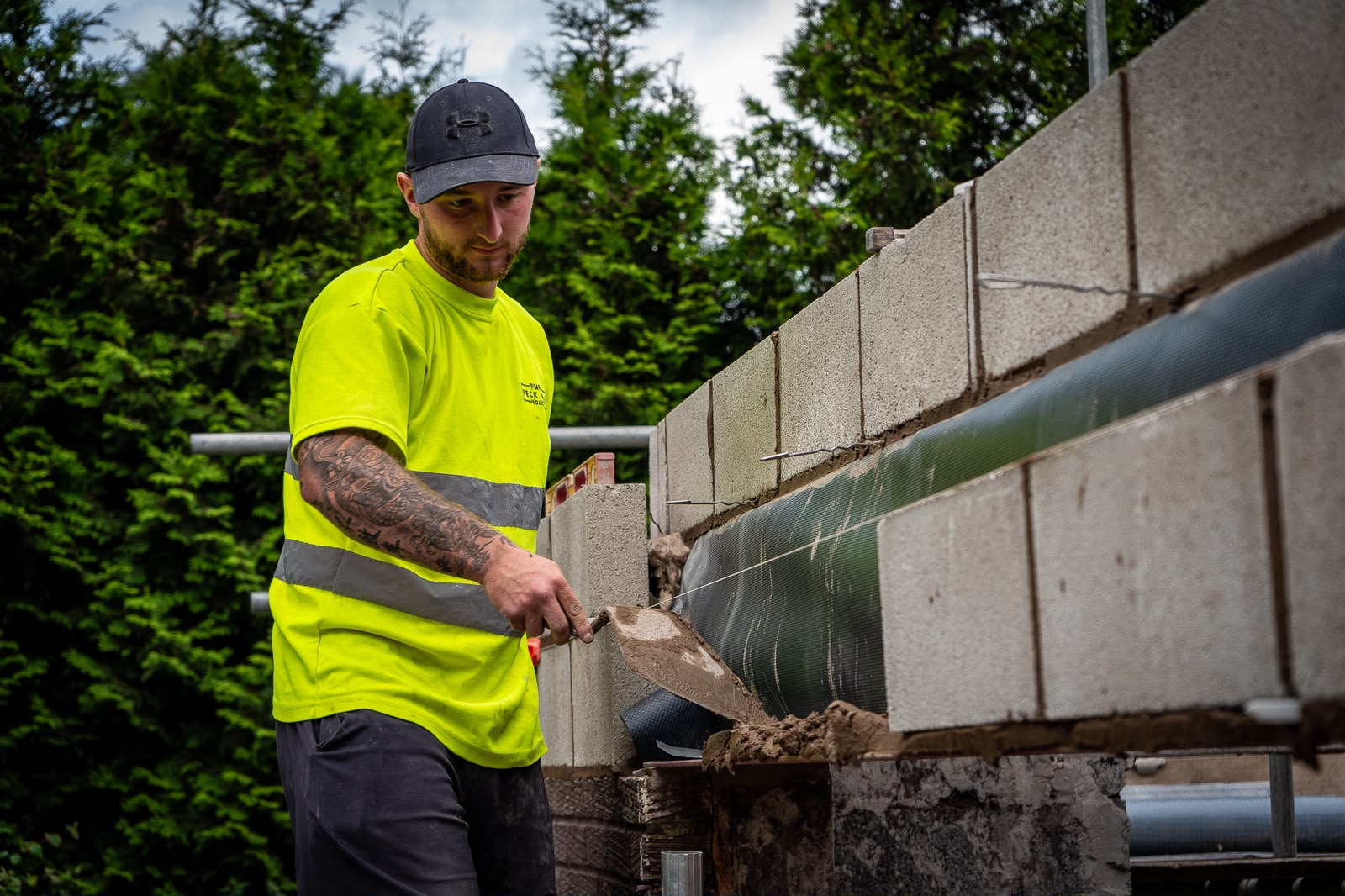 First Course Brickwork bricklayer working in high-visibility clothing